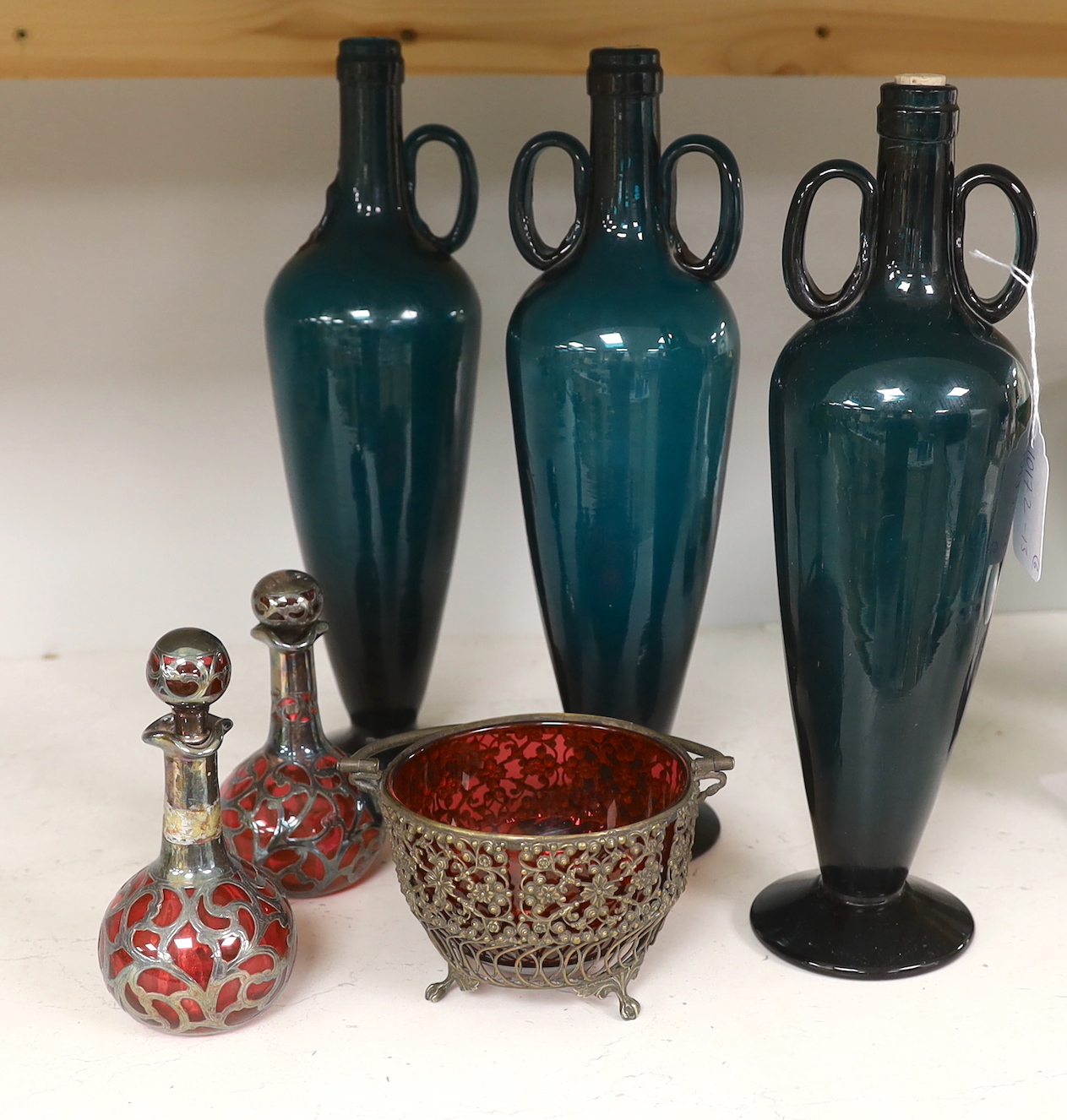 Three green glass flasks, a ruby glass basket and two overlaid ruby glass scent bottles, tallest 33cm (5)